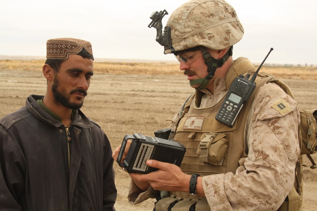 Capt. Christopher A. Banweg, a Reserve Marine civil affairs officer with 4th Civil Affairs Group, teaches a local Afghan farmer how to operate a radio Dec. 10, 2009.  Banweg, 31, was originally a financial management officer before joining the Marine Corps Reserve in 2004. In addition to entering a new career field, the reserves has also afforded Banweg the opportunity to shoot on the Marine Corps Reserve Rifle Team and serve as a combat marksmanship instructor. (Photo copyright, The Christian Science Monitor)